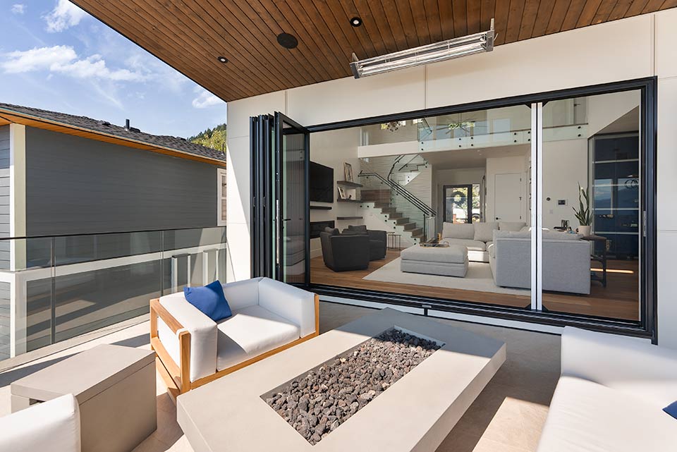 Contemporary patio with retractable screen and folding glass doors, blending indoor and outdoor living space.